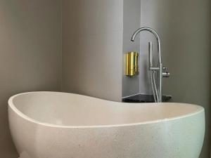a white bath tub in a bathroom with a faucet at Leonora Hotel in Ho Chi Minh City