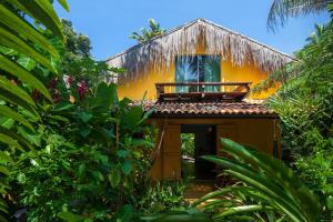 żółty dom z balkonem na górze w obiekcie Pousada Canoa Nativa w mieście Ilha de Boipeba