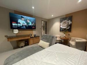 a bedroom with a bed and a flat screen tv at Leonora Hotel in Ho Chi Minh City