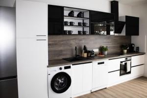 a kitchen with white cabinets and a washing machine at Lucky Strike Hostel in Bad Oldesloe