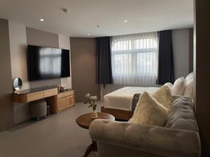 a living room with a couch and a bed at Leonora Hotel in Ho Chi Minh City