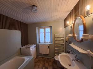 a bathroom with a tub and a sink and a mirror at Nouveau - Maison Nierveze proche Lioran in Thiézac +13 photos
