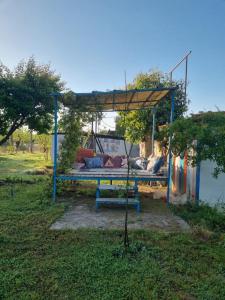 a pergola with a bed in the grass at Şahmeran Pansiyon in Kemer