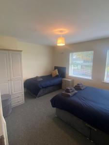 two beds in a bedroom with blue sheets at Carrickasticken House in Dungooly Cross Roads