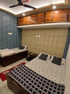 a bedroom with two beds and a ceiling at ROOMS vala in Varanasi