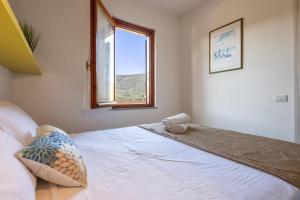 a bedroom with a large white bed with a window at L11 Terrazza Maestrale in Stintino +33 photos