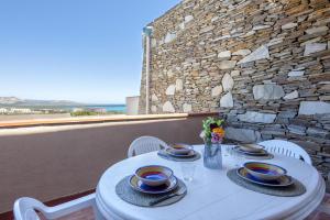 a white table with chairs and plates on it at L11 Terrazza Maestrale in Stintino