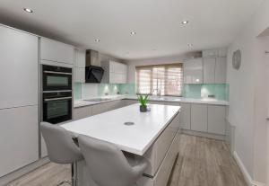 a kitchen with white cabinets and a white counter top at Holgate Lodge in York