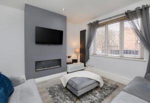 a living room with a fireplace and a tv on the wall at Holgate Lodge in York +8 photos