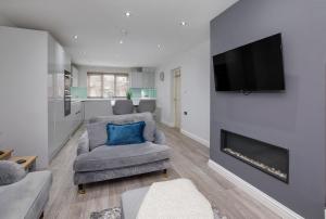 a living room with a couch and a tv on a wall at Holgate Lodge in York