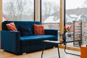a blue couch in a living room with a table at "Happy Vibes" City Appartment in Passau