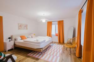 a bedroom with a large bed and orange curtains at "Happy Vibes" City Appartment in Passau