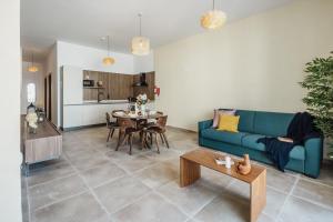 a living room with a blue couch and a table at St Julians`s Boho Apartments in Is-Swieqi