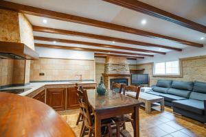 a kitchen and living room with a table and a couch at Villa Oropéndola para familias, a pocos minutos de Granada, Piscina agua salada, Parking privado, Barbacoa, Chimenea, 14 pax in Belicena