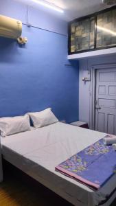 a bed in a room with a blue wall at Atithi homestay Solapur in Solapur