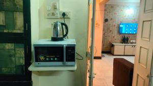 a microwave with a tea kettle on top of it at Atithi homestay Solapur in Solapur