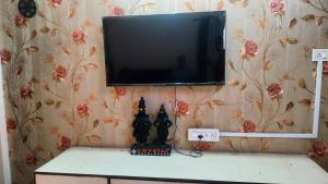 a flat screen tv on a wall with flowers at Atithi homestay Solapur in Solapur
