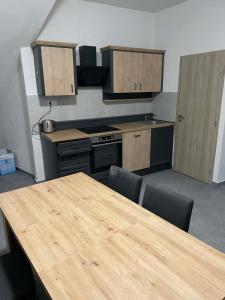 an empty kitchen with a wooden table and chairs at Ubytování Jimramov in Jimramov