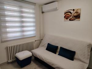 a small room with a bed and a window at Apartman Pavlica in Kragujevac