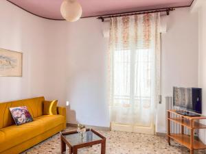 a living room with a yellow couch and a window at Orchidea 2 - Pineto Vacanza in Pineto