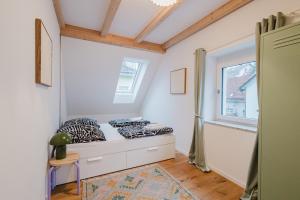 a bedroom with a bed and a window at Stadtblick Passau Apartment in Passau