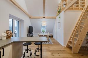a kitchen and living room with a wooden table and stairs at Stadtblick Passau Apartment in Passau