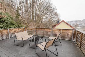 three chairs and a table on a deck at Stadtblick Passau Apartment in Passau
