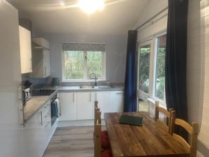 a kitchen with a wooden table and a sink at Willow Valley in Bude
