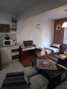 a small room with a bed and a table at Пандова къща in Sandanski