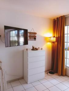 a room with a dresser and a television on the wall at Appartement Golf et Océan in Moliets-et-Maa