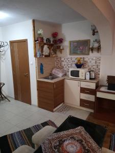 a small kitchen with a sink and a microwave at Пандова къща in Sandanski +7 photos
