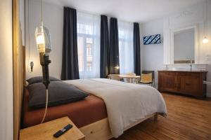 a bedroom with a large bed and a bathroom at LA MAISON FIVES - Esprit Hôtel Design - Lille in Lille