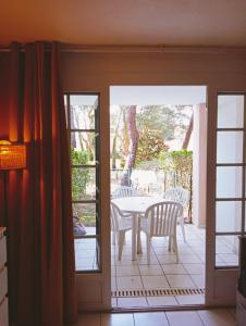 an open door to a patio with a table and chairs at Appartement Golf et Océan in Moliets-et-Maa