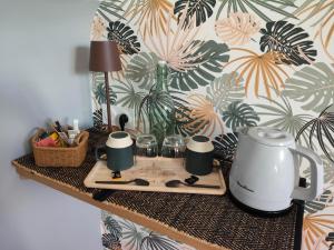 a table with a coffee pot and glasses on it at Entre terre et baie à 15 mn du Mont-Saint-Michel in Pontaubault