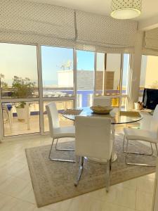 a living room with a table and chairs and a view of the ocean at Villa grand large in Tamraght Ouzdar