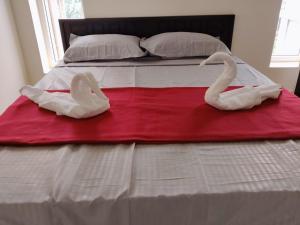 two swans are sitting on top of a bed at SRC Mahal in Killai +1 photo
