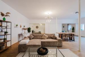 a living room with a couch and a dining room at Boho Loft Apartment am Ziegeltor in Amberg