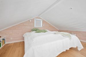 a bedroom with a white bed in a attic at Fantastisk havsutsikt i Ulebergshamn in Hunnebostrand