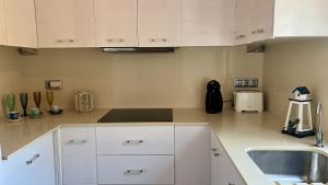 a kitchen with white cabinets and a sink at La Esquineta de Tabarca in Tabarca +32 photos