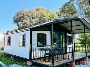 a tiny house on a trailer with a porch at Beautiful Pradise 1 in Penfield