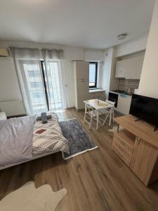a bedroom with a bed and a table and a kitchen at Studio Residential Vitan in Bucharest