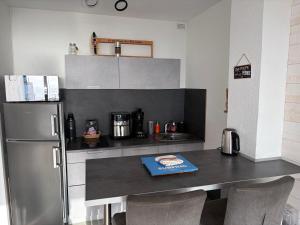 a kitchen with a table and a refrigerator at Appartement face océan in Lacanau
