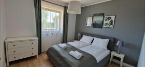 a bedroom with a bed with two towels on it at Wzgórze Wadery Siekierczyna in Siekierczyna