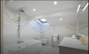 a white bathroom with a tub and a toilet at Central luxury duplex in Cannes