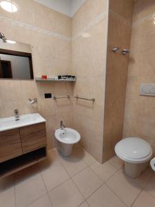 a bathroom with a toilet and a bidet and a sink at Isola Holiday in Feltre