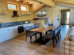 a kitchen and dining room with a wooden table and chairs at Almlodge Westendorf in Westendorf +27 photos