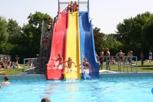 a group of people on a water slide in a pool at 5 persoons lodge in Witmarsum