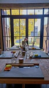 a long wooden table with a group of tables with glasses at B&B En face du Marronnier in Cornimont