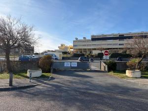 a parking lot in front of a building with a stop sign at Appartement face océan in Lacanau