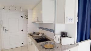 a small kitchen with a sink and a counter top at Holiday 3401 in Roses